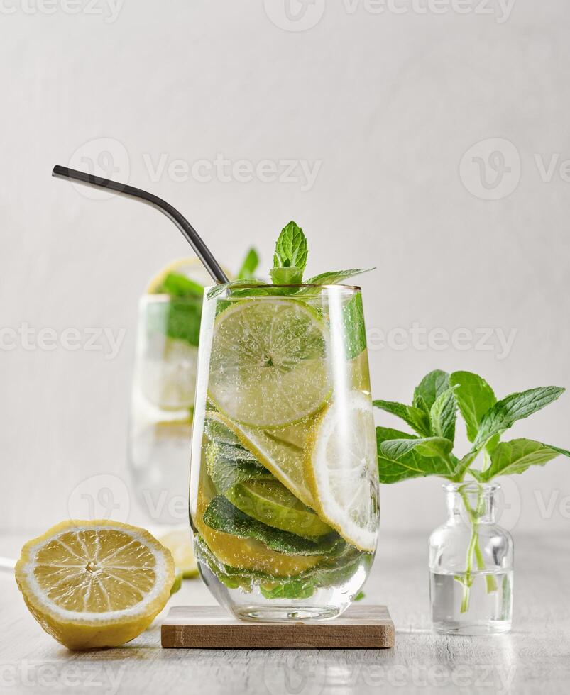 Summer drink with lime and mint. Cold drink, non-alcoholic mojito or lemonade, garnished with fresh mint sprigs and citrus slices photo