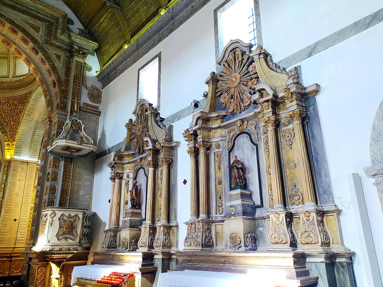 NAZARE, PORTUGAL - NOVEMBER 02, 2024 Elaborate interior of a church. Intricate gilded details adorn the altars, pulpit, and ceiling, showcasing rich religious architecture. photo