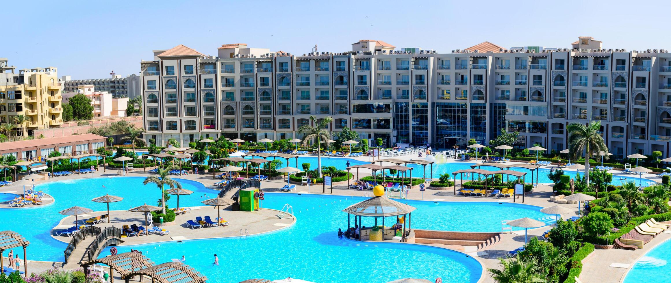 SHARM EL SHEIKH, EGYPT - JUNE 09, 2017 Resort complex featuring multiple swimming pools, sunbeds, umbrellas and palm trees. Luxury vacation and tourism concept. photo