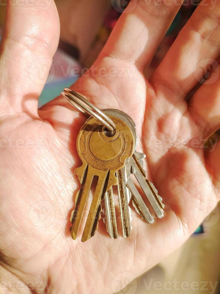 Keys in hand symbolize opportunity, access, and security. Perfect for concepts around real estate, travel, solutions, or unlocking potential. photo