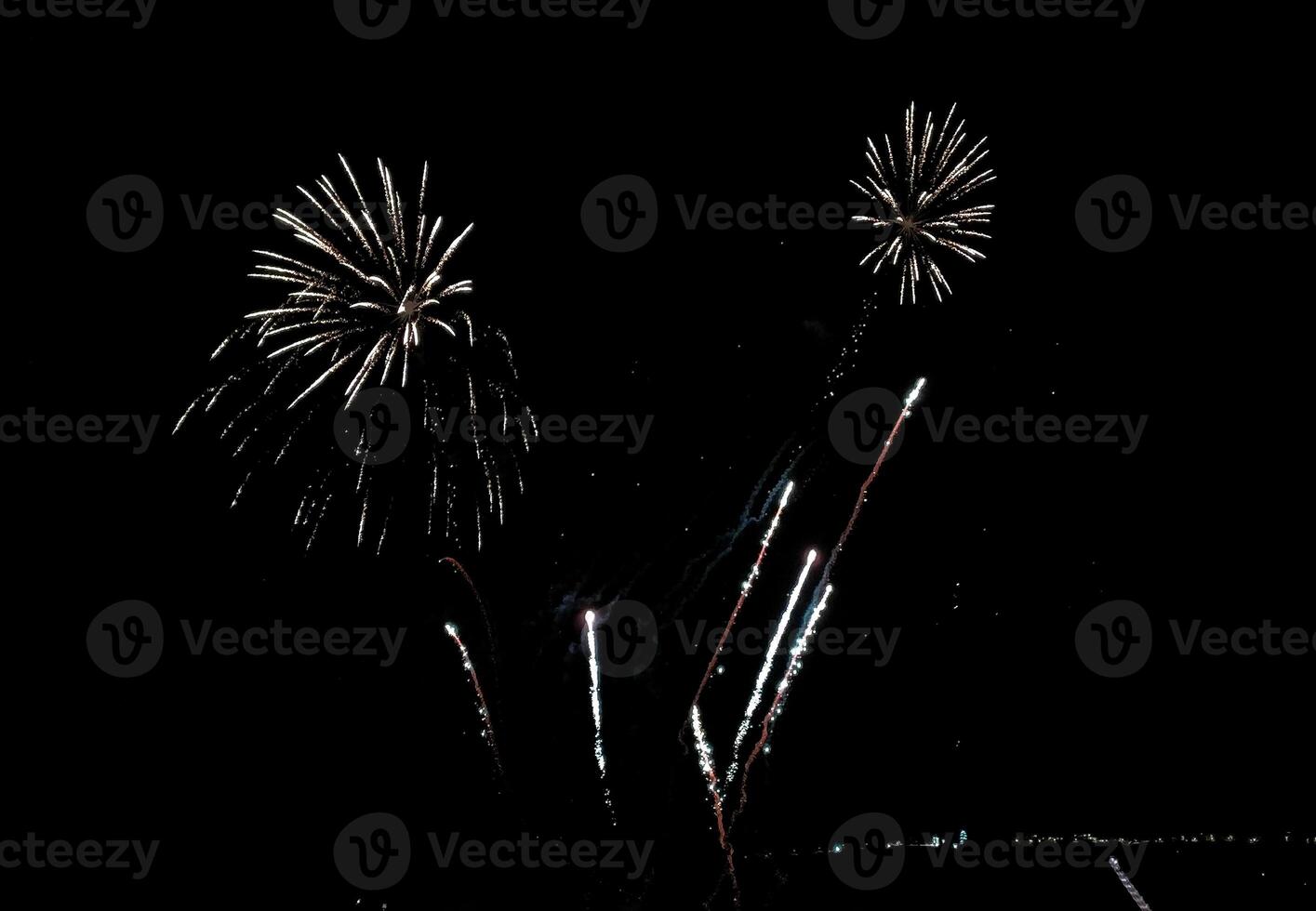 Stunning fireworks display against a dark night sky. Bright bursts of light create a vibrant and celebratory scene, perfect for holiday or event promotions. photo