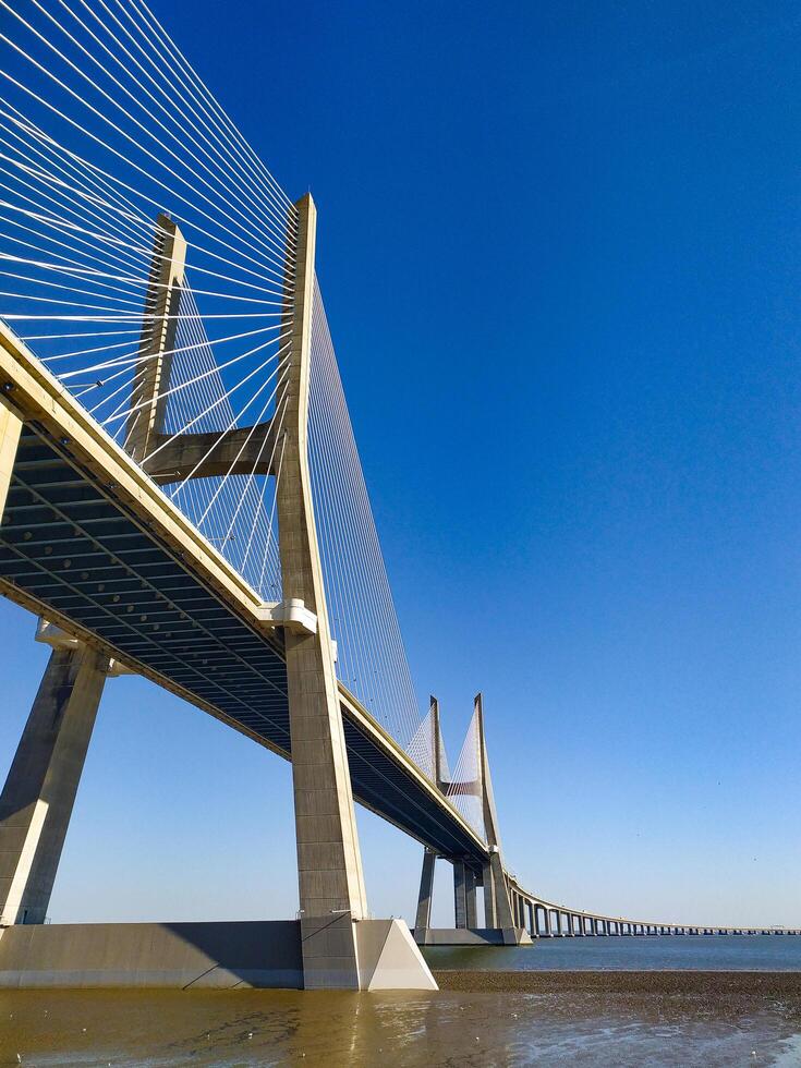 LISBON, PORTUGAL - JANUARY 17, 2025 Cablestayed bridge under clear blue sky. Modern architecture, engineering marvel. Travel, tourism, infrastructure, and transportation concepts. photo