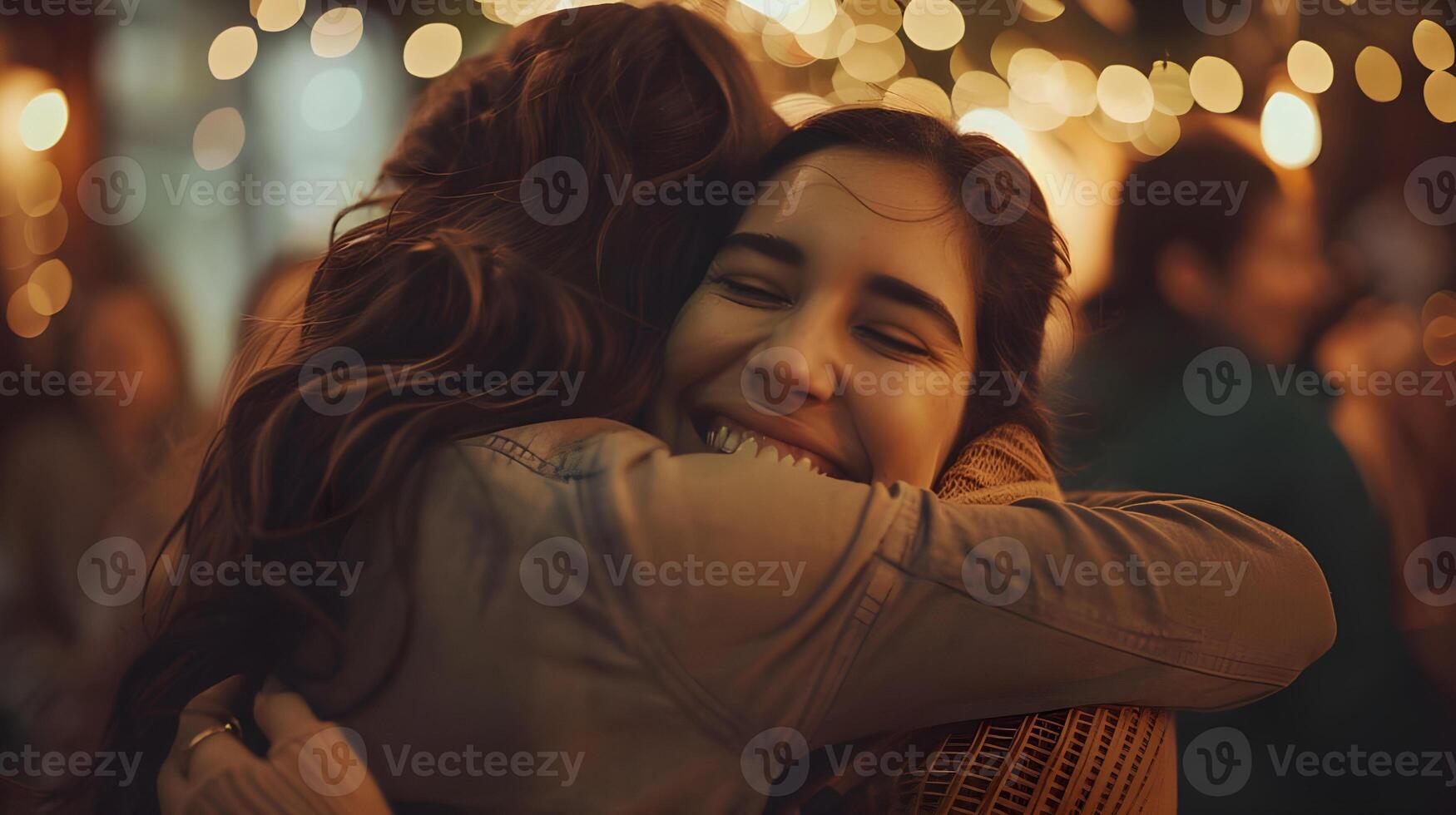 Two women hugging in front of a crowd of people photo