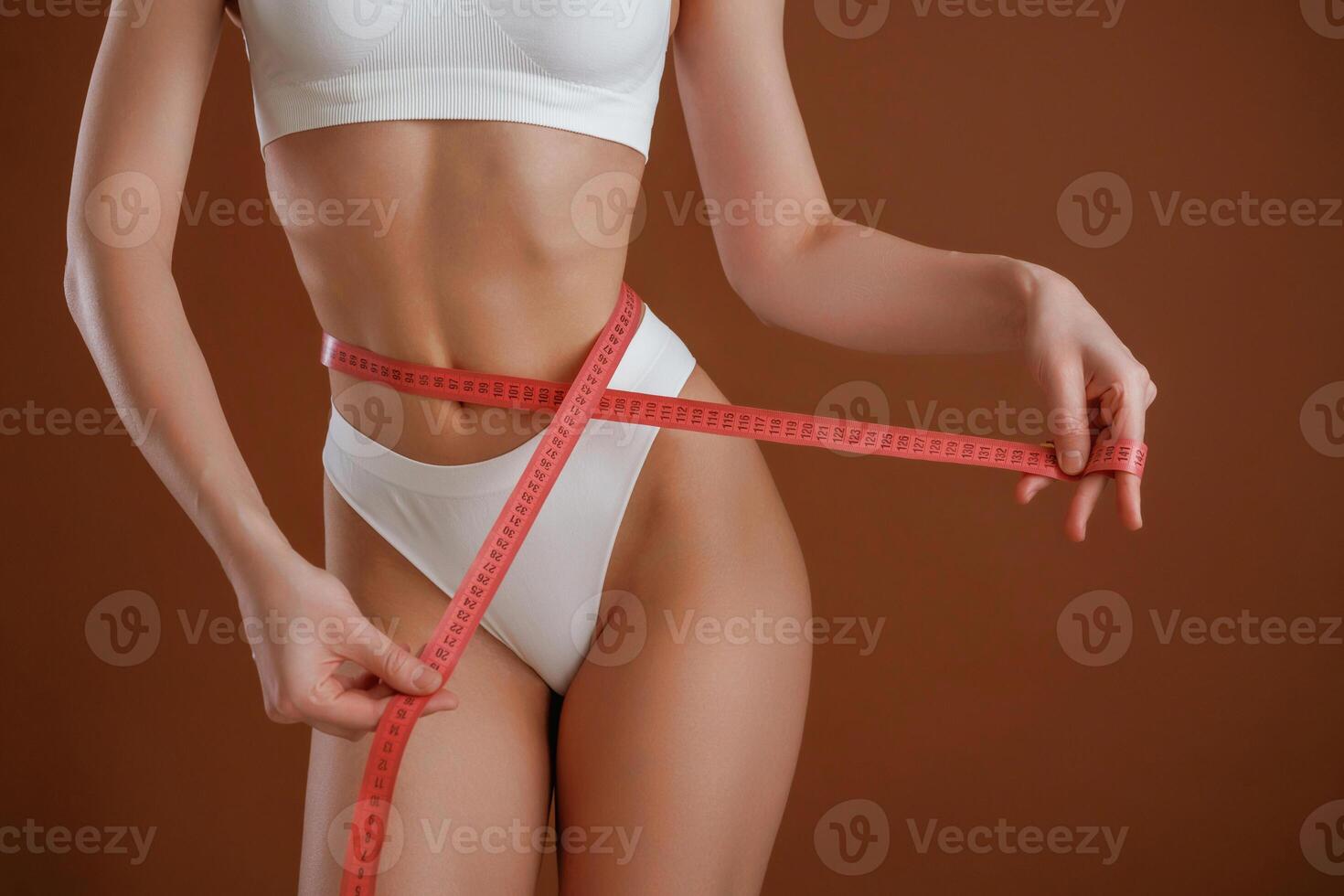 Dieting ,conception, with ,measuring ,tape. Woman with slim body shape is posing against background photo