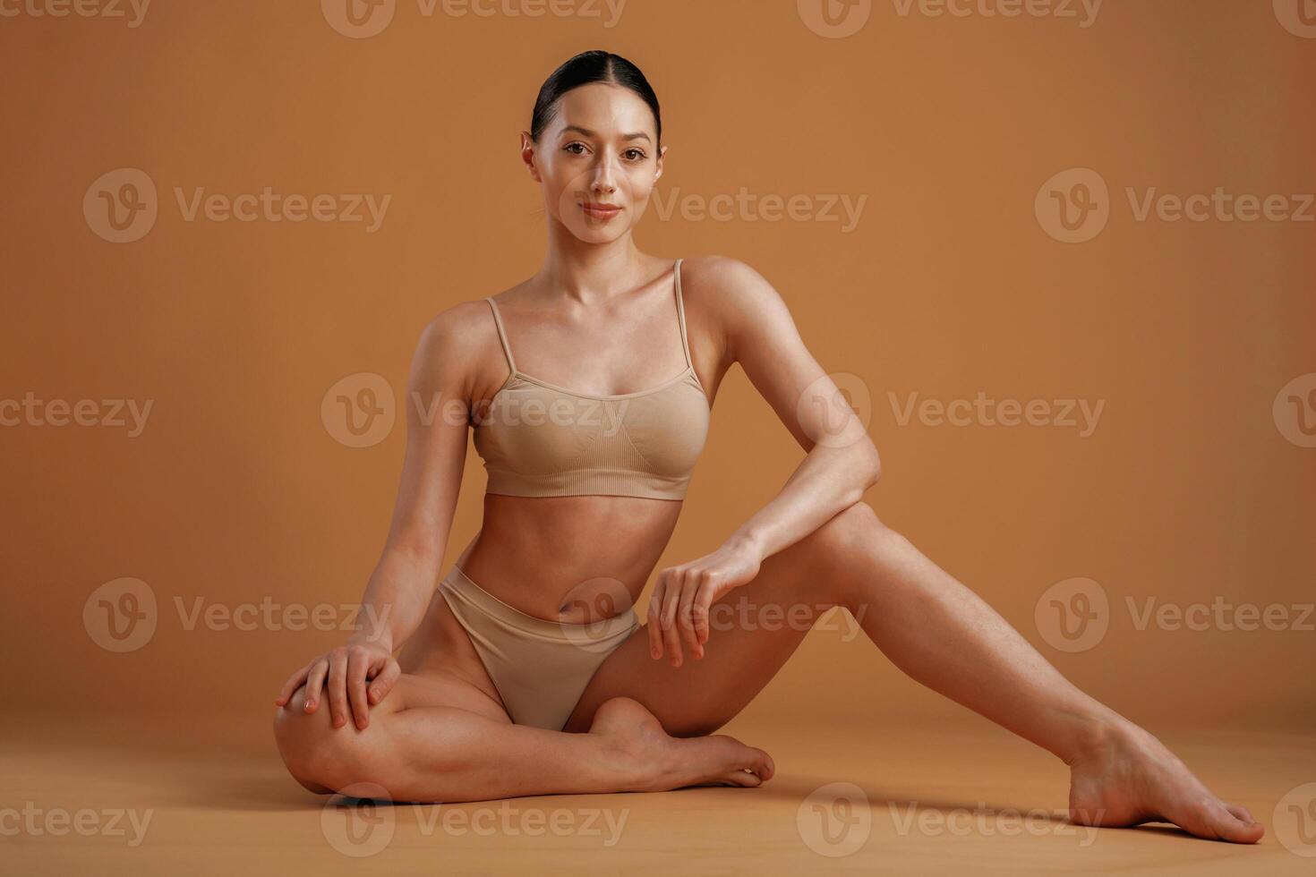 Professional, photoshoot. Woman, with slim body shape is posing against background photo