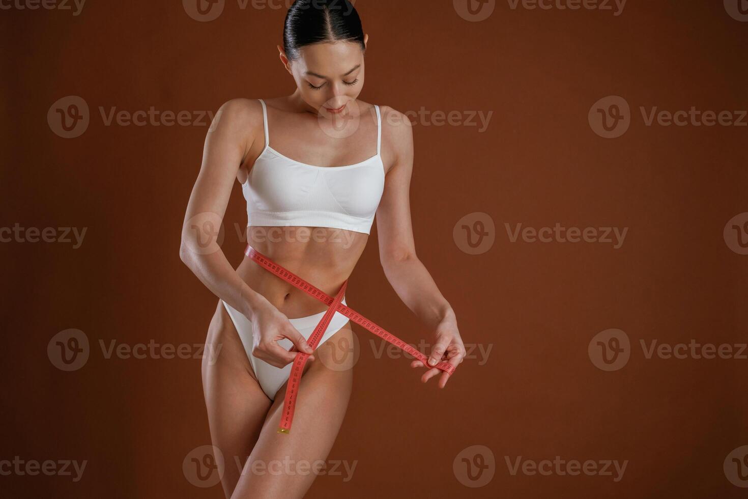 Dieting, conception, with measuring,, tape. Woman with slim body shape is posing against background photo