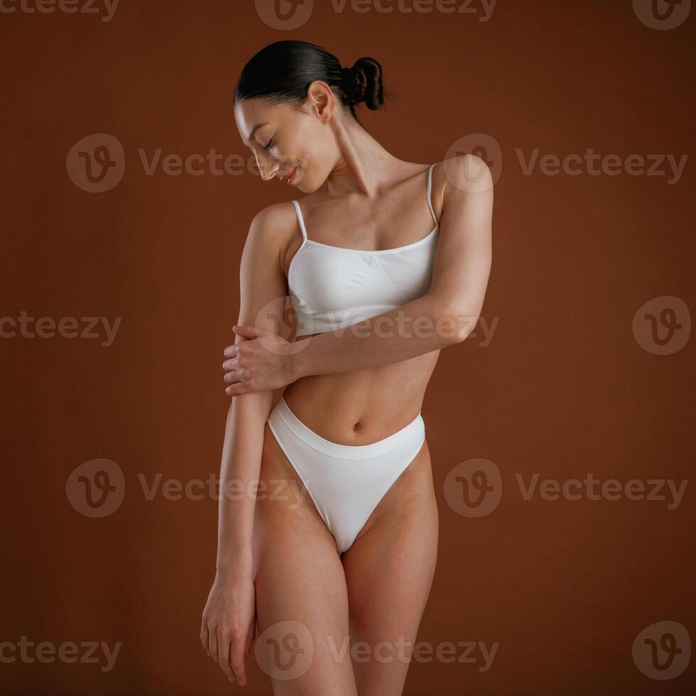 Showing,brand ,,new underwear. Woman with slim body shape is posing against background photo
