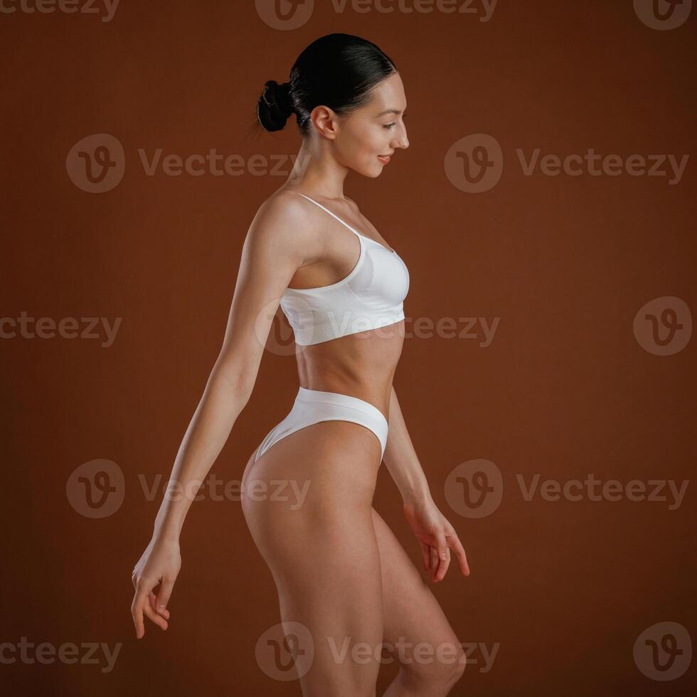 New, underwear collection. Woman, with ,slim body shape is posing against background photo