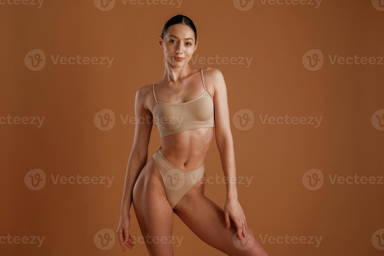 Skinny girl. Woman ,with slim body shape is posing against background photo