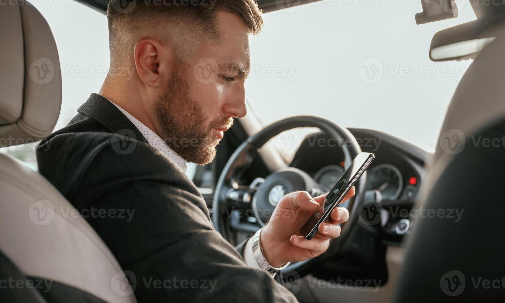 Man in black suit ,is, sitting in the car, driving photo