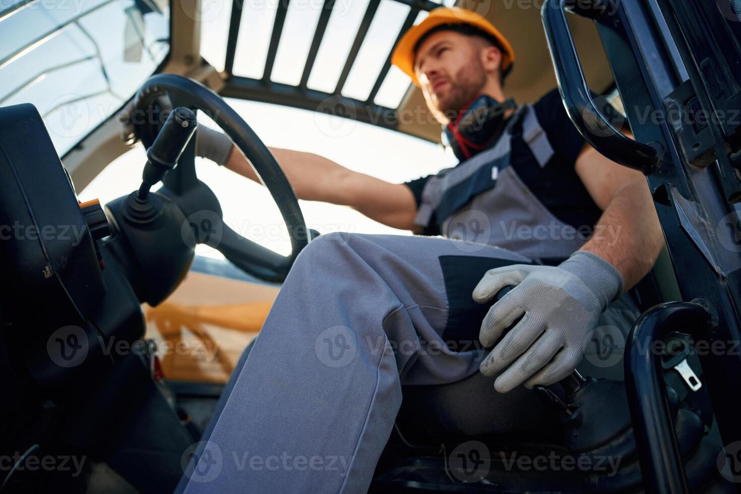 Sitting in the ,vehicle. Man is with tractor. Agricultural worker photo