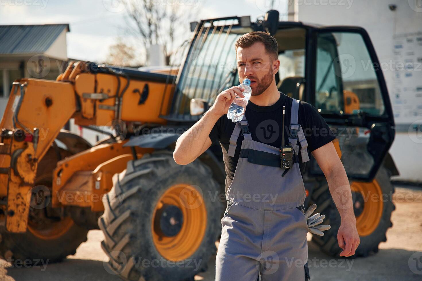 Drinking water,,, taking a break, tired. .Man is with tractor. Agricultural worker photo