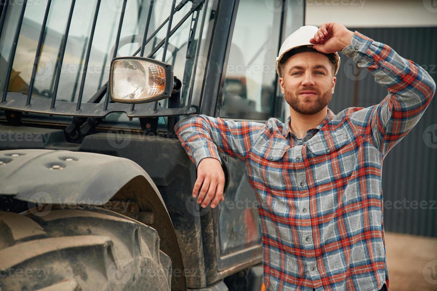 Leaning on,, ,the, vehicle. Man is with tractor. Agricultural worker photo