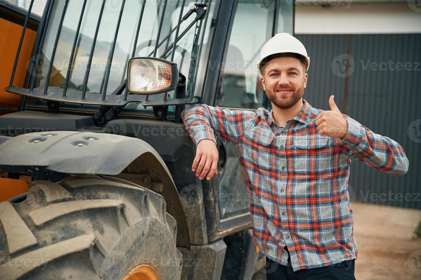 Leaning on, the vehicle. Man is with tractor. Agricultural worker photo