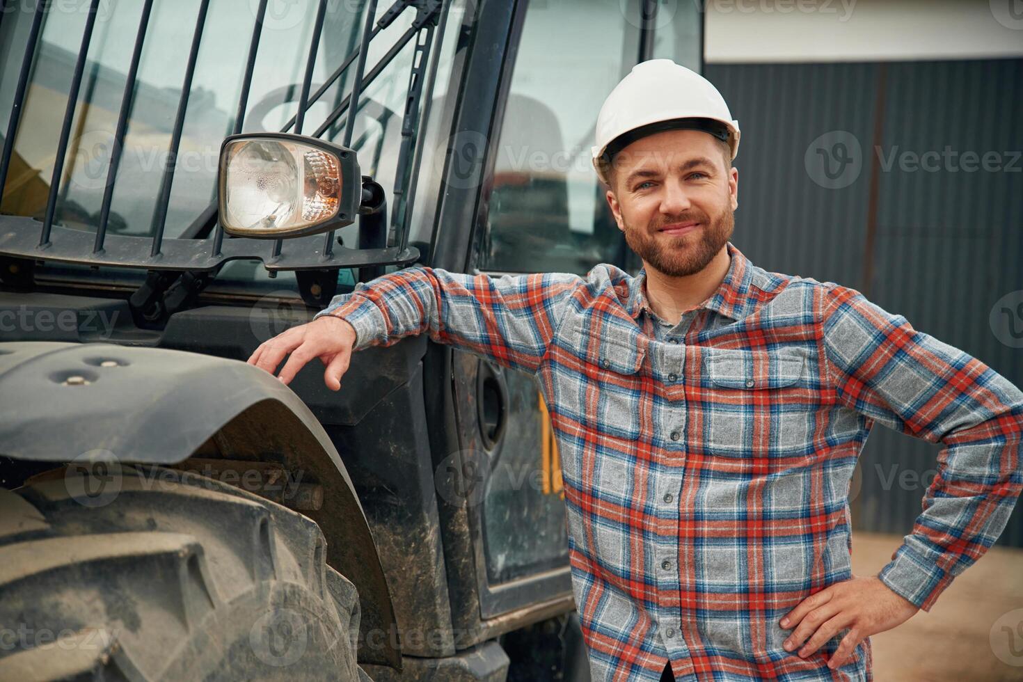 Leaning on ,the, vehicle. Man ,is ,with, tractor. Agricultural worker photo