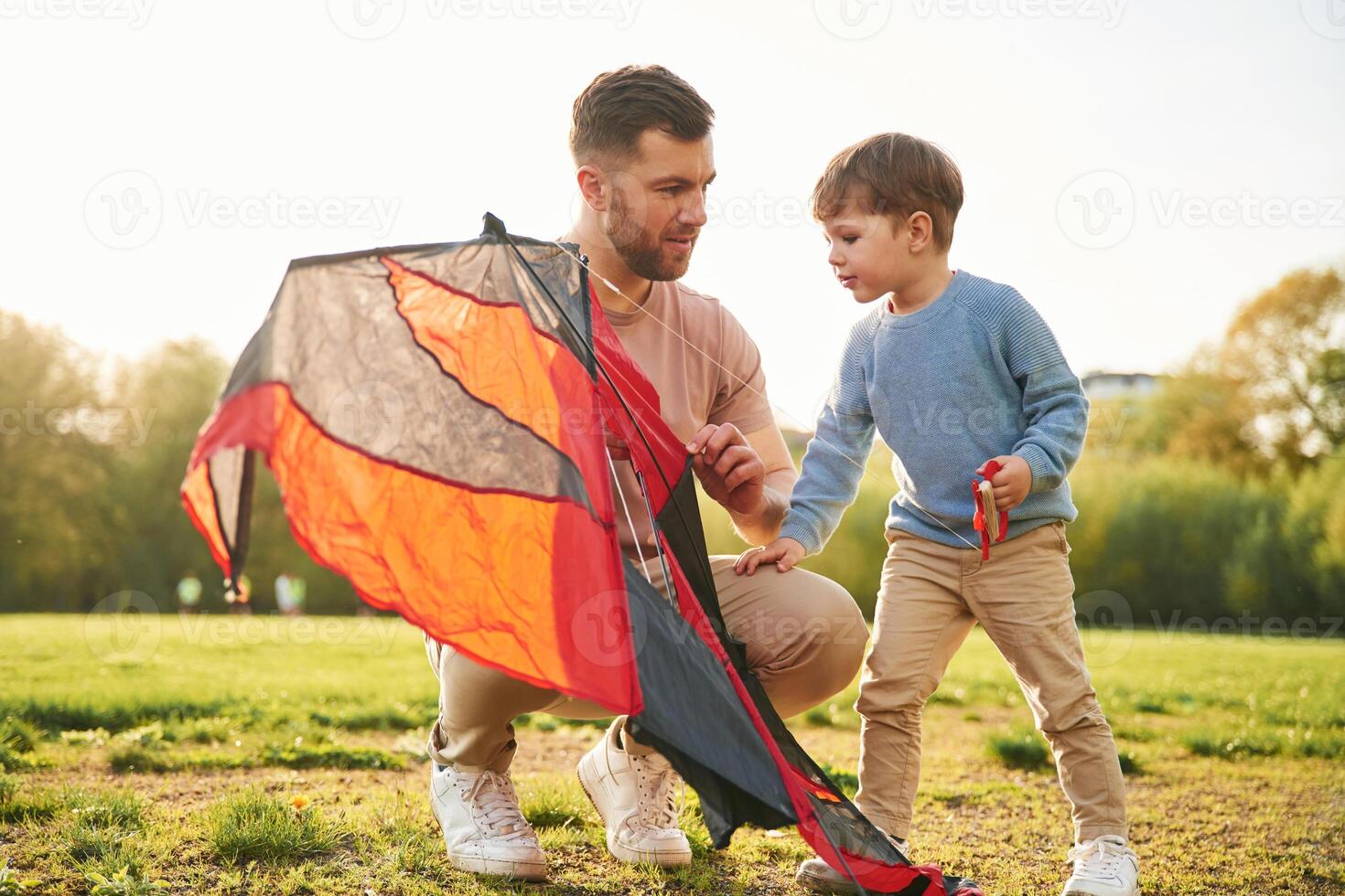 Red kite. Happy ,father with ,son are having fun on the field at summertime photo