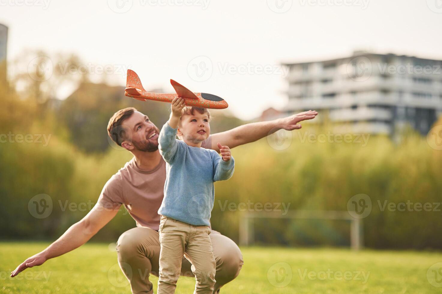 Freedom, playing with ,,toy ,plane. Happy father with son are having fun on the field at summertime photo