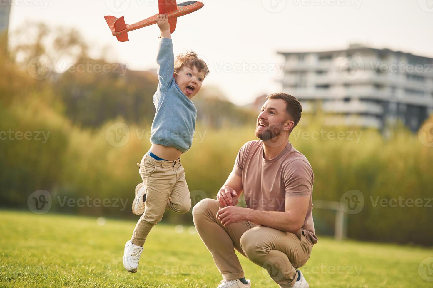 Freedom, playing,, with toy plane. Happy father with son are having fun on the field at summertime photo