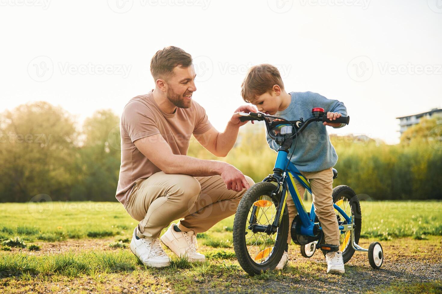 With, bicycle, having ,fun. Happy father with son are on the field at summertime photo