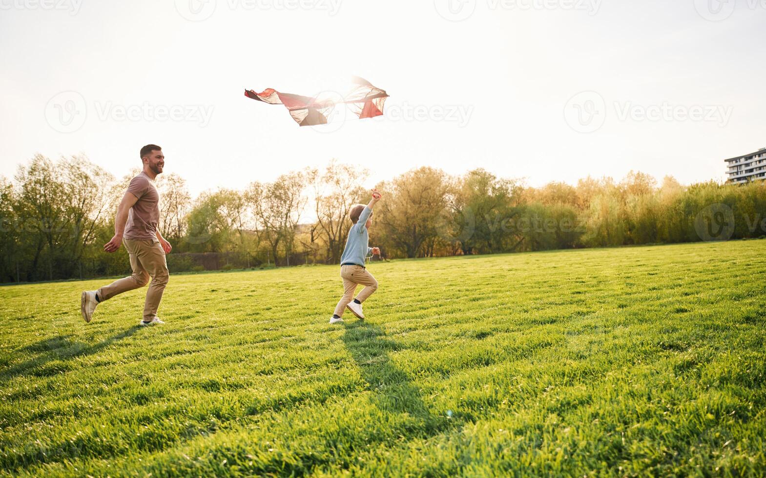 Red kite.. Happy father with son are having fun on the field at summertime photo