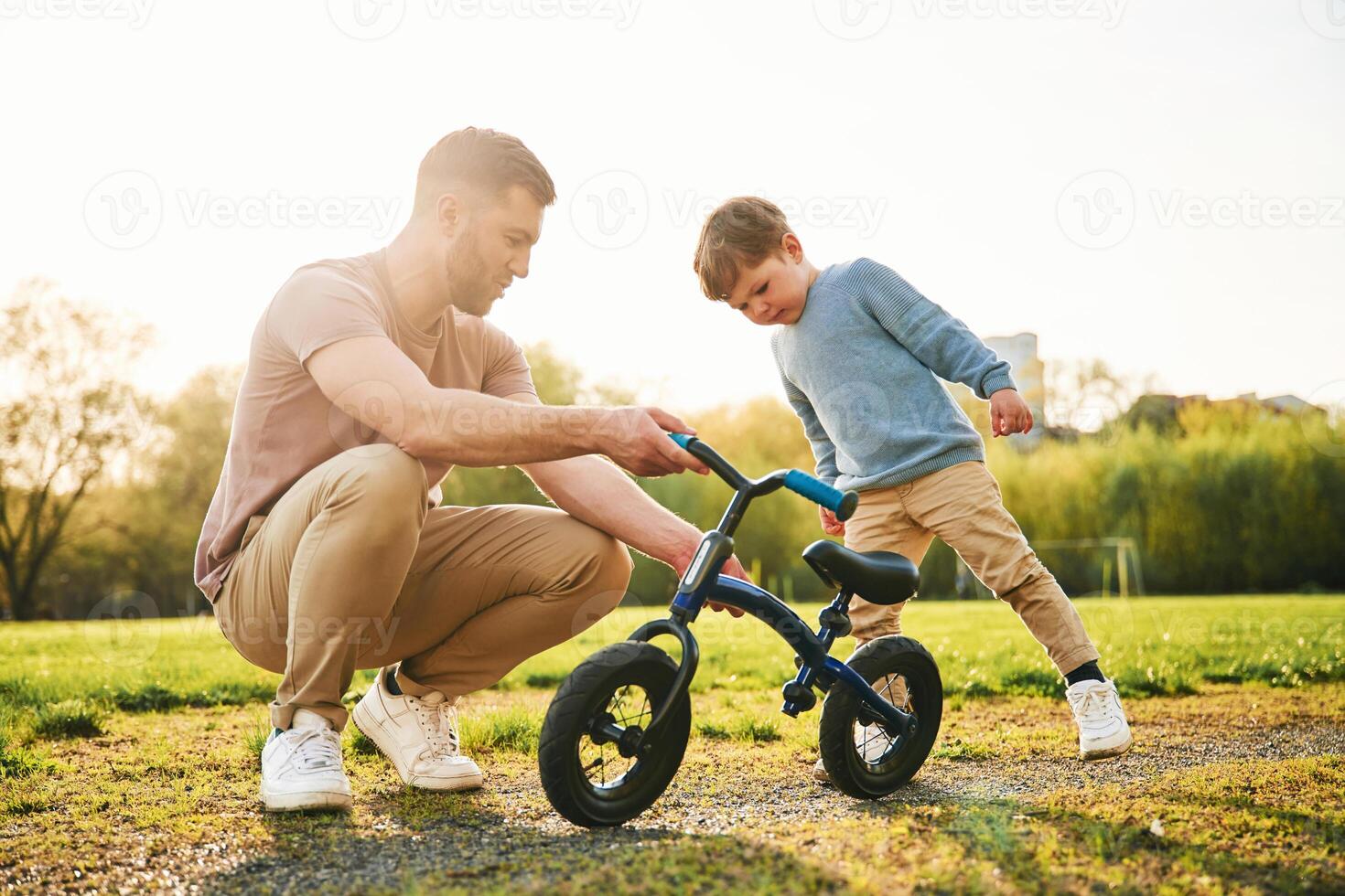 Bicycle, having ,fun. Happy father with son are on the field at summertime photo