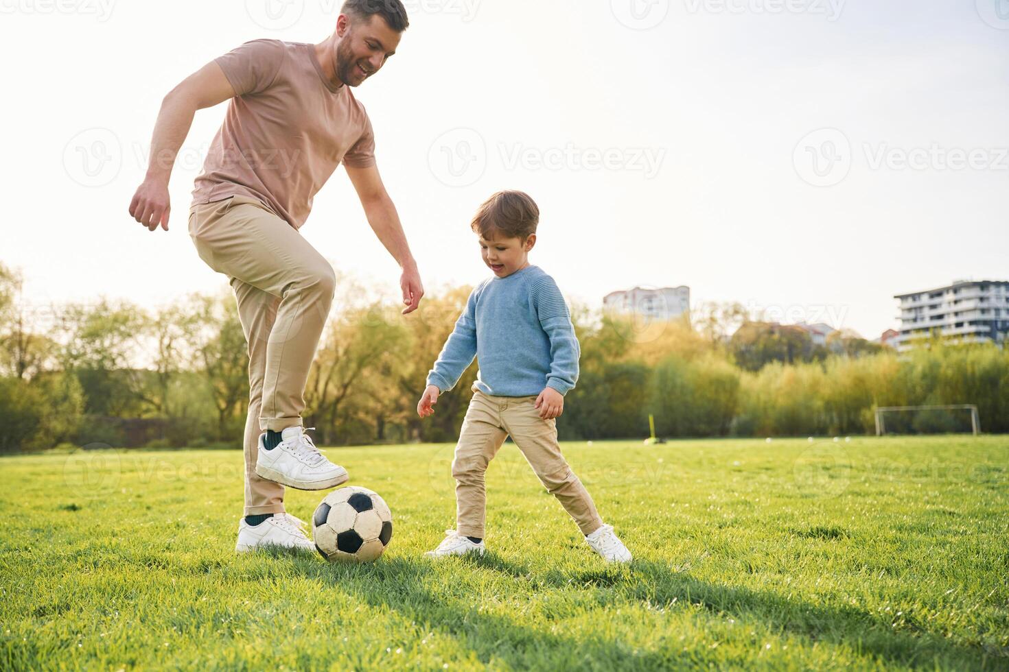 Playing soccer.. Happy father with son are having fun on the field at summertime photo