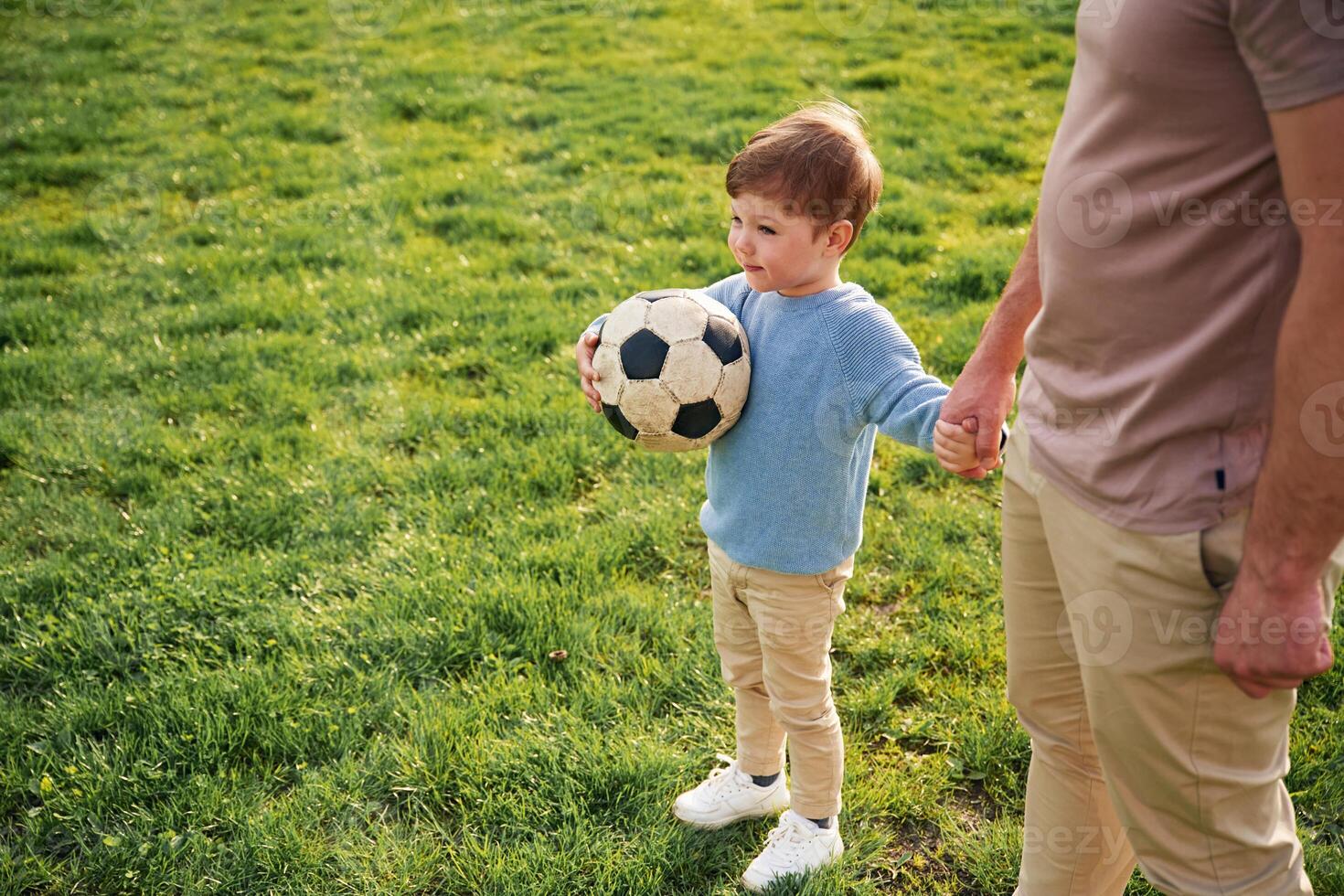 Game of ,soccer. With ball. Happy father with son are having fun on the field at summertime photo