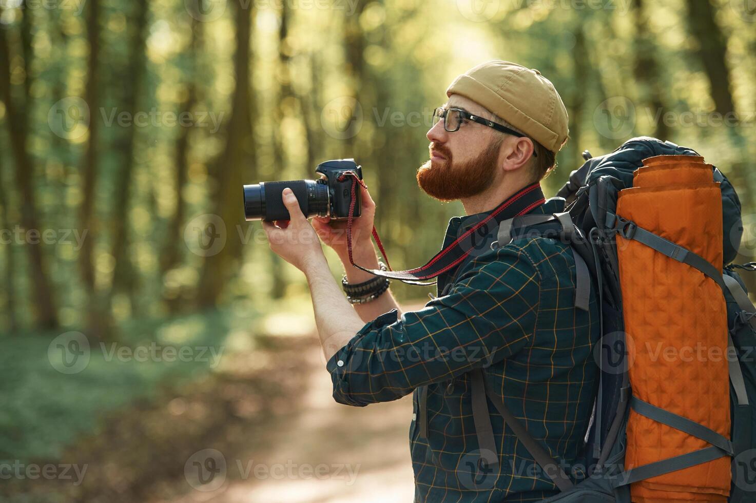 Photographer, with, camera. Bearded man is in the forest at daytime photo
