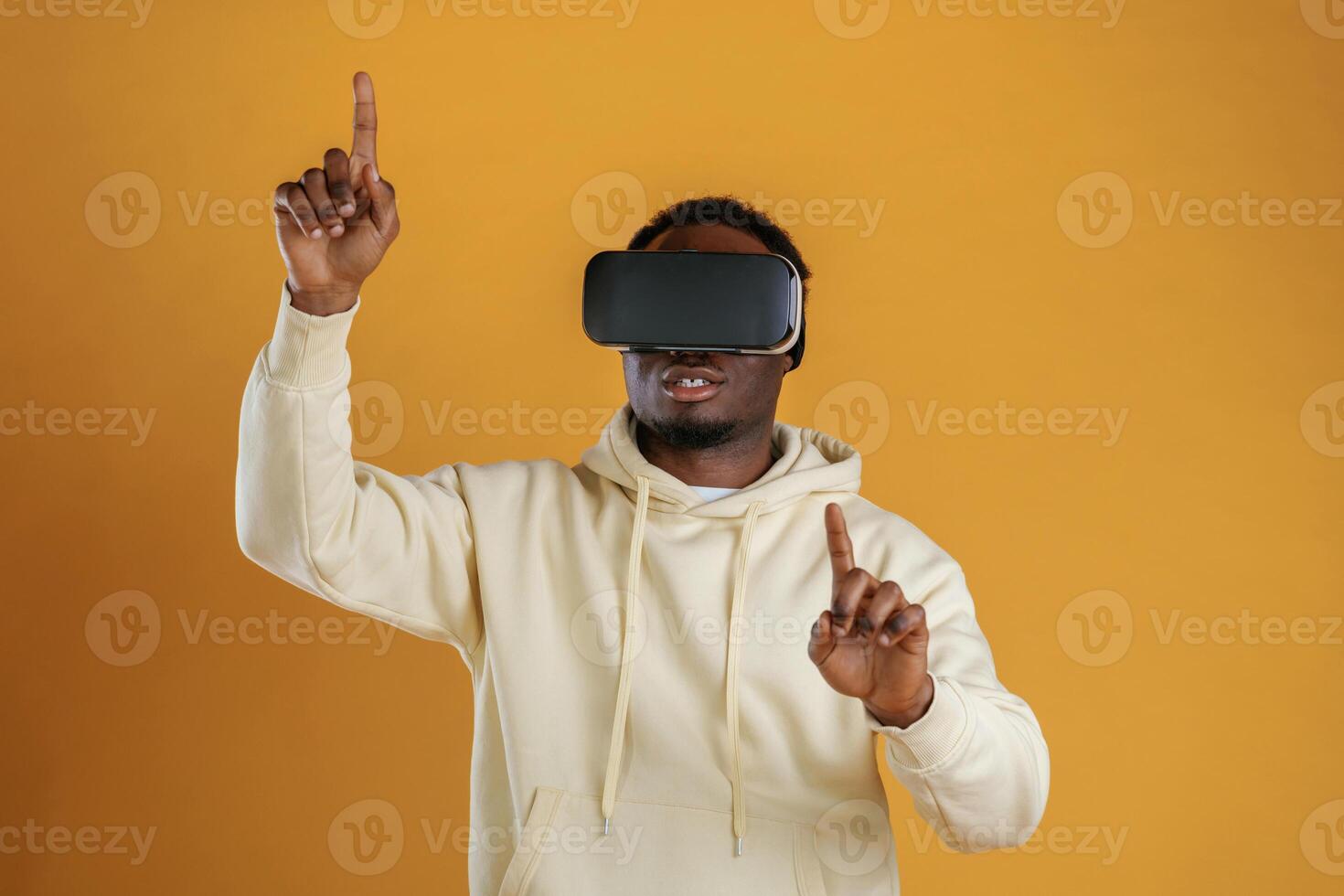 Playing VR game.. In, virtual reality, glasses. Black guy is against yellow background photo