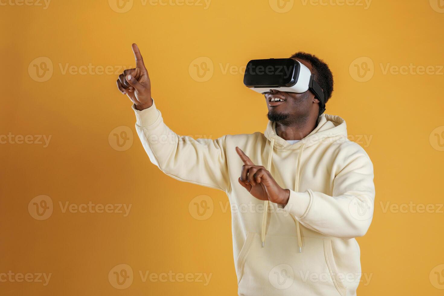 Playing VR game. .In virtual reality glasses. Black guy is against yellow background photo