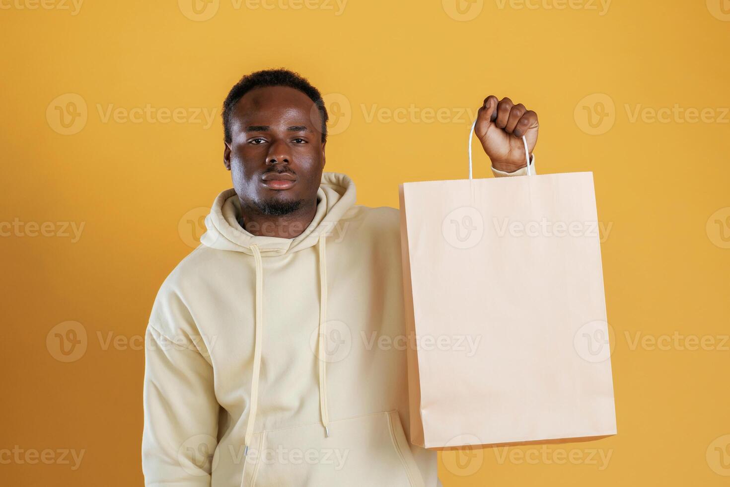 Bag, with copy space, conception of shopping. Black guy is against yellow background photo