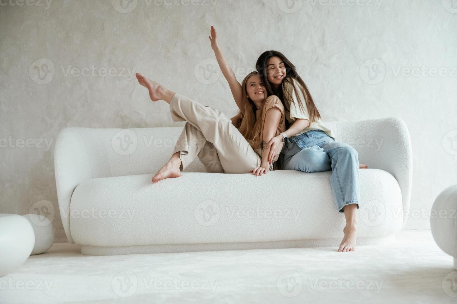 Looking, ,forward, sitting. Two, happy young female best friends are indoors photo