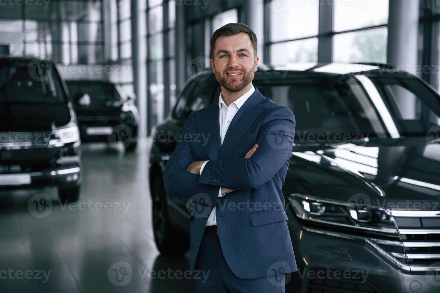 Cheerful salesman. Guy is ,in, a car dealership photo