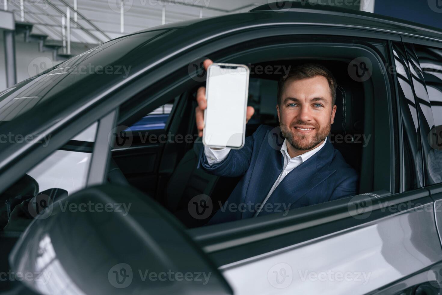 Smartphone, with copy space on display. Businessman is in the brand new car,, photo