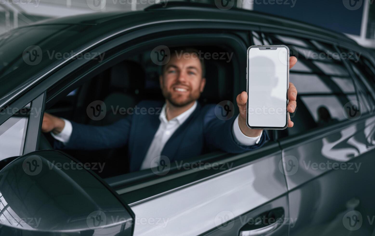 Smartphone with, copy space on display. Businessman is in the brand new car photo