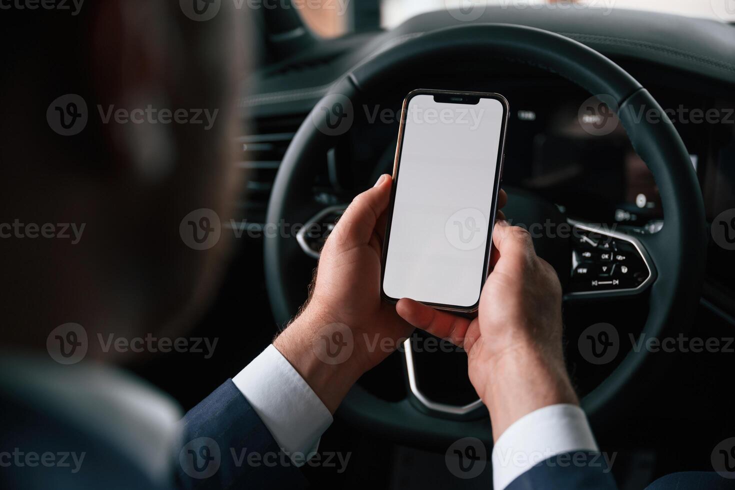 White copy, space on smartphone. Businessman is in the brand new car photo