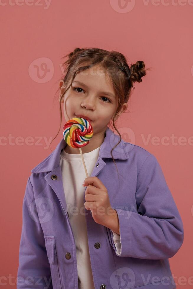 Close up,, view,, with ,candy. Cute little girl is against pink background photo