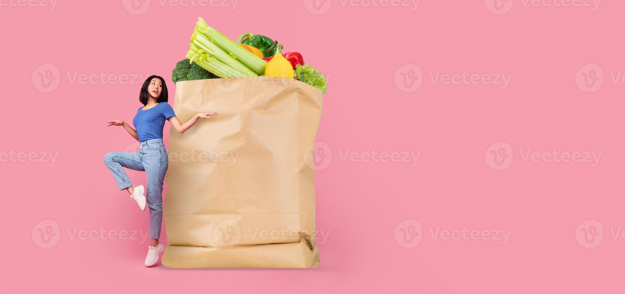 A customer stands next to a large paper bag brimming with fresh vegetables like lettuce, broccoli, and peppers. This highlights the new normal of grocery shopping and delivery. photo