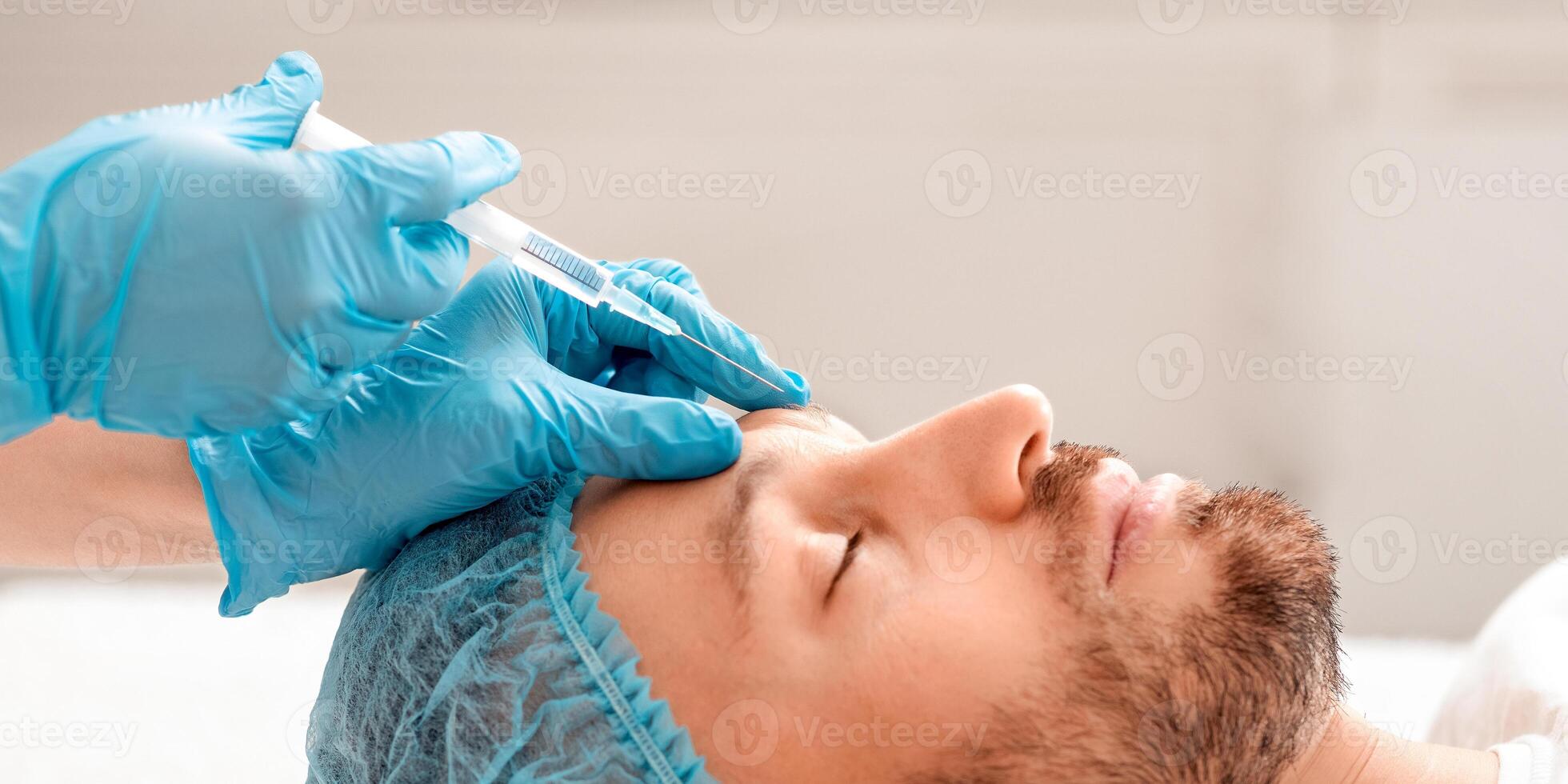 Middle aged man visiting aesthetic clinic, getting beauty injection, side view. Bearded man in hair net attending cosmetologist, having frown lines treatment from plastic surgeon, closeup photo
