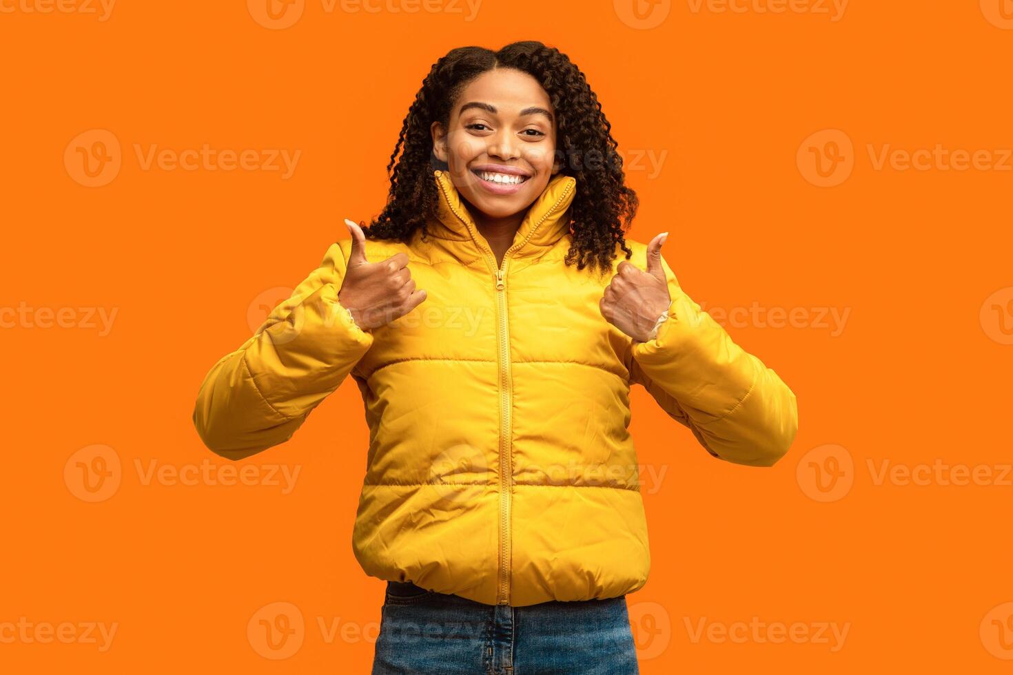 I Like It. Black Girl Gesturing Thumbs Up With Both Hands Posing On Yellow Studio Background photo