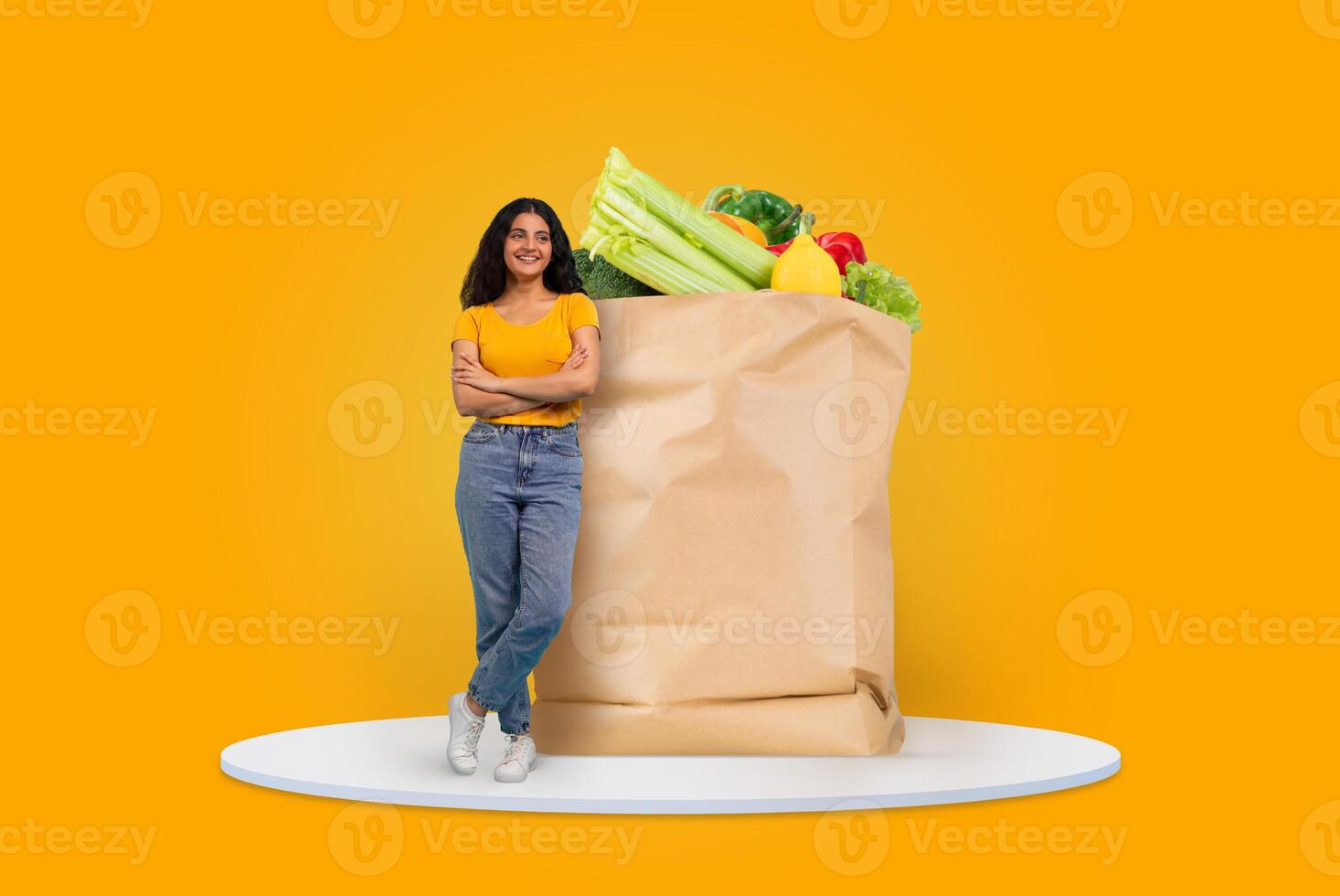 A customer stands confidently next to a large paper bag brimming with colorful vegetables and fruits. The bright background emphasizes the joy of shopping for groceries in today's market. photo