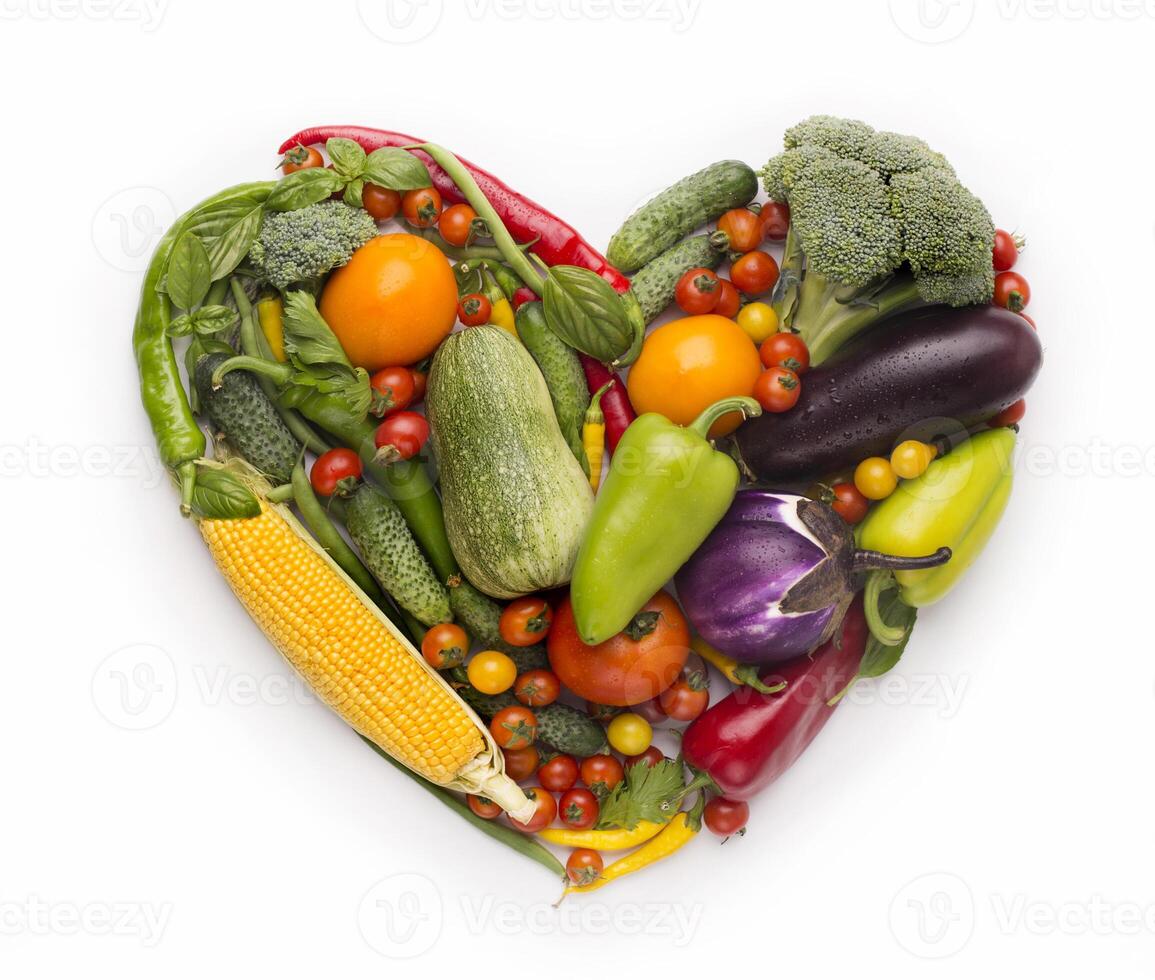Healty diet concept. Heart shape frame of fresh vegetables on white background photo
