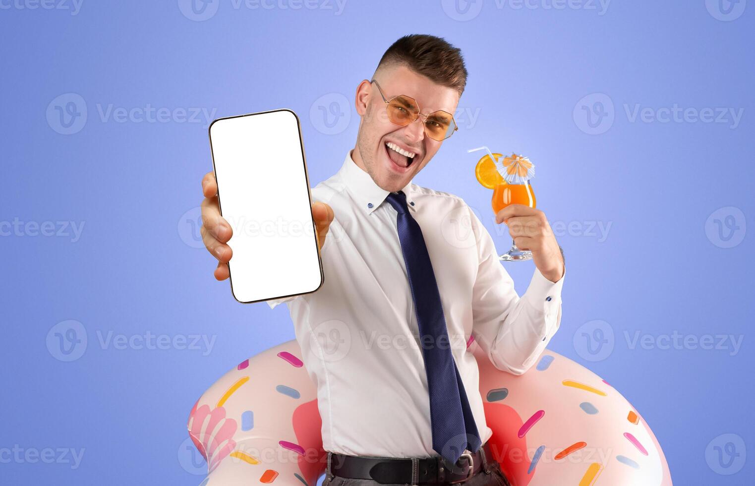 Excited young businessman with passport, plane tickets, inflatable ring and refreshing cocktail ready for summer vacation, blue background photo