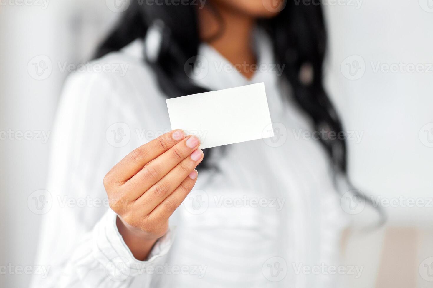 Closeup of businesswoman showing blank business card with mockup for design at modern office. Unrecognizable female manager holding empty advertising card with space for text photo