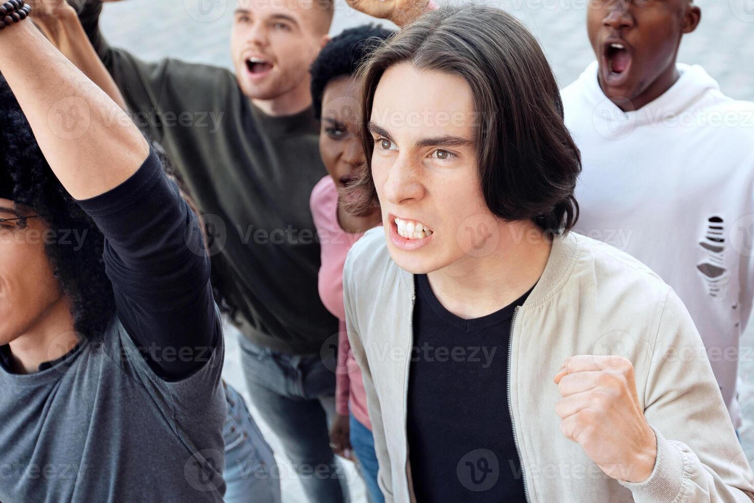 Anti-pollution strike concept. Top view of international group of angry people making strike on street, chanting slogans, raising fists up, demanding from government saving planet, reducing pollution photo