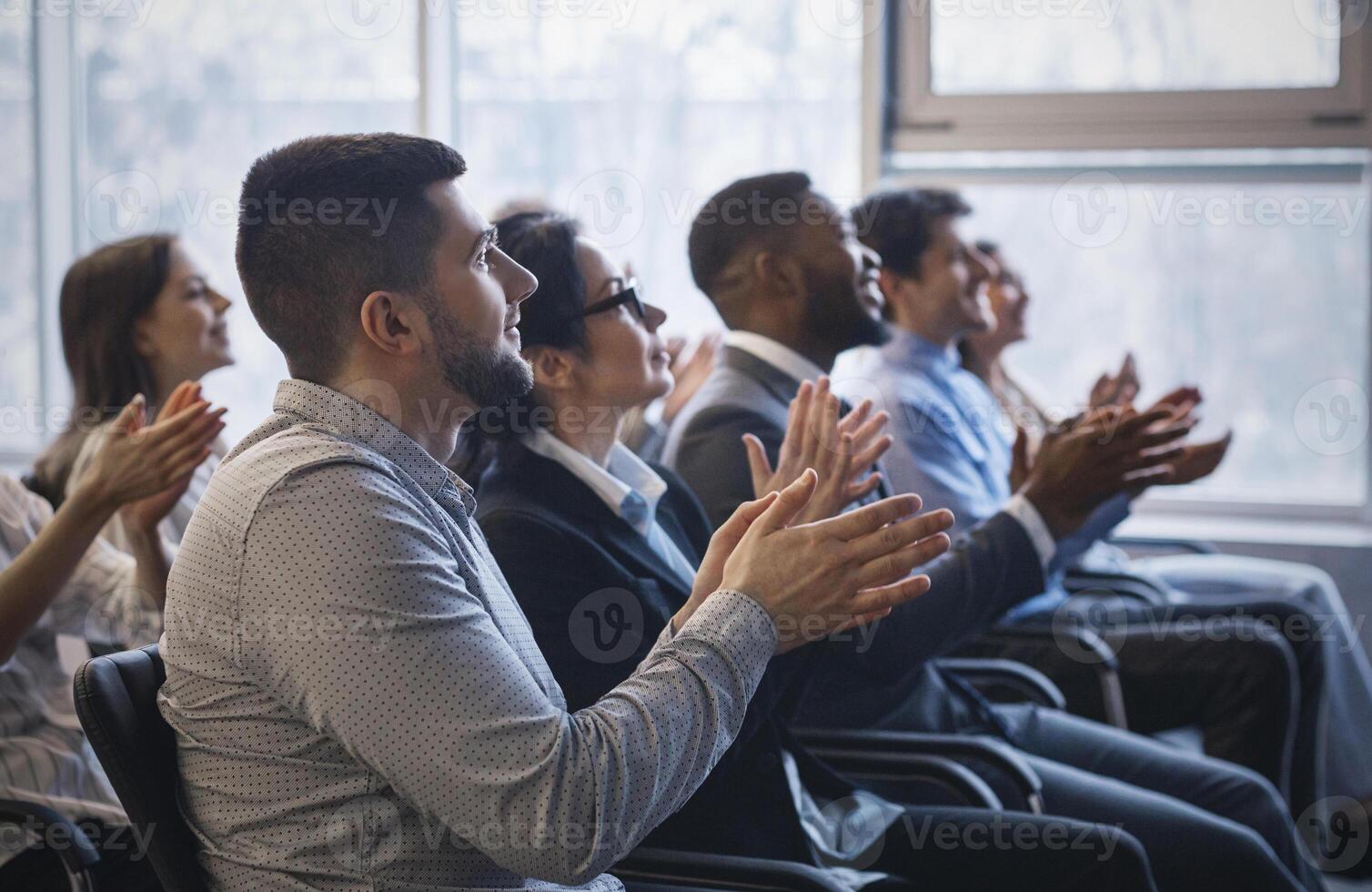Business conference. Colleagues clapping hands to speaker at seminar photo