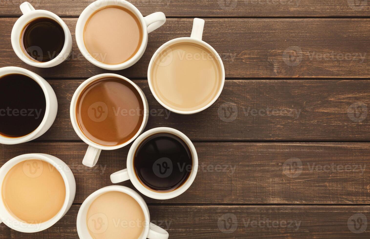 Border of various kinds of coffee in cups of different size on rustic wooden table, top view, copy space photo