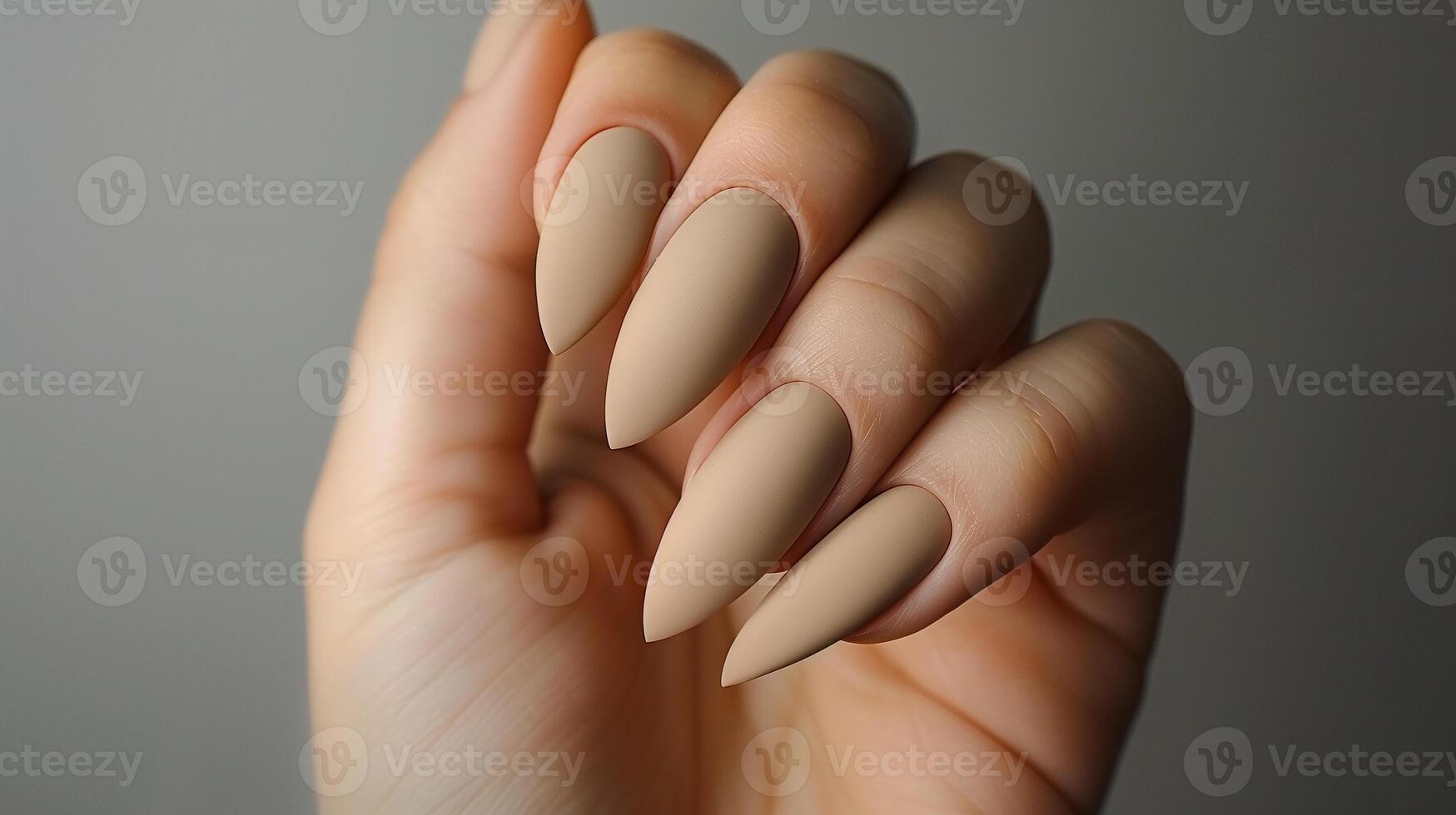 This Close-up of soft beige almond-shaped nails with a matte finish, showcasing nail care techniques. photo
