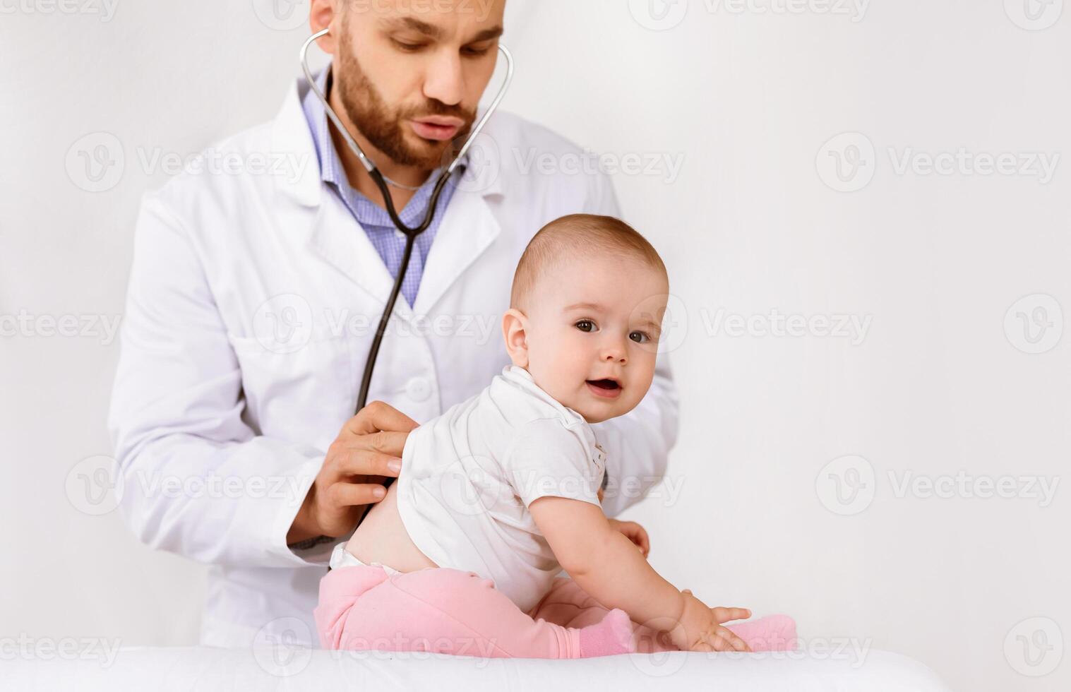 Medical Checkup. Doctor Examining Little Baby Girl Listening To Her Lungs With Stethoscope Over White Studio Background. Child Health, Sick Little Patient Having Pediatrician Appointment In Clinic photo