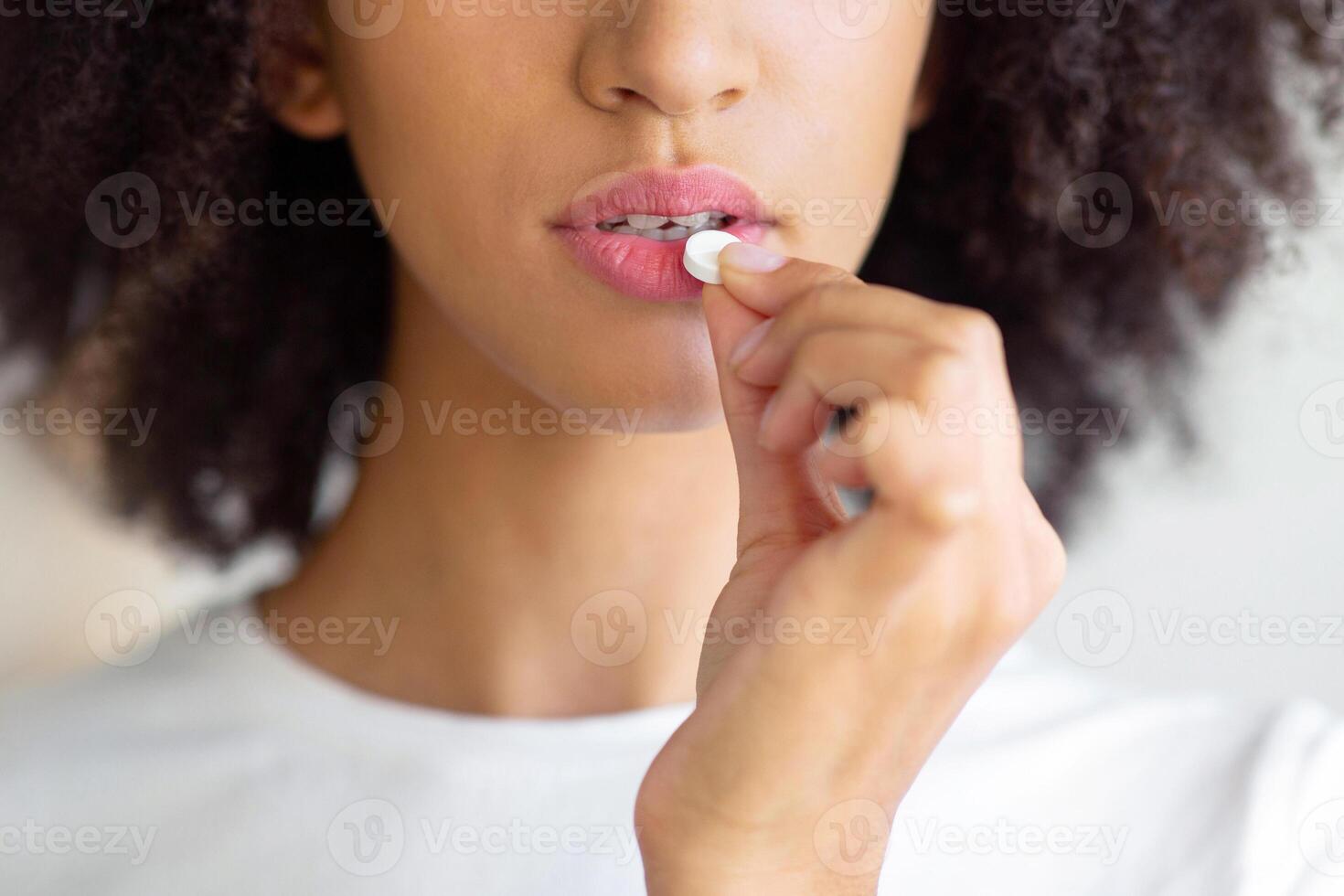 Illness, flu and cold, feeling unwell, high fever, headache, migraine and medication. Serious young african american lady suffering from pain taking pills or vitamins, close up, free space, cropped photo